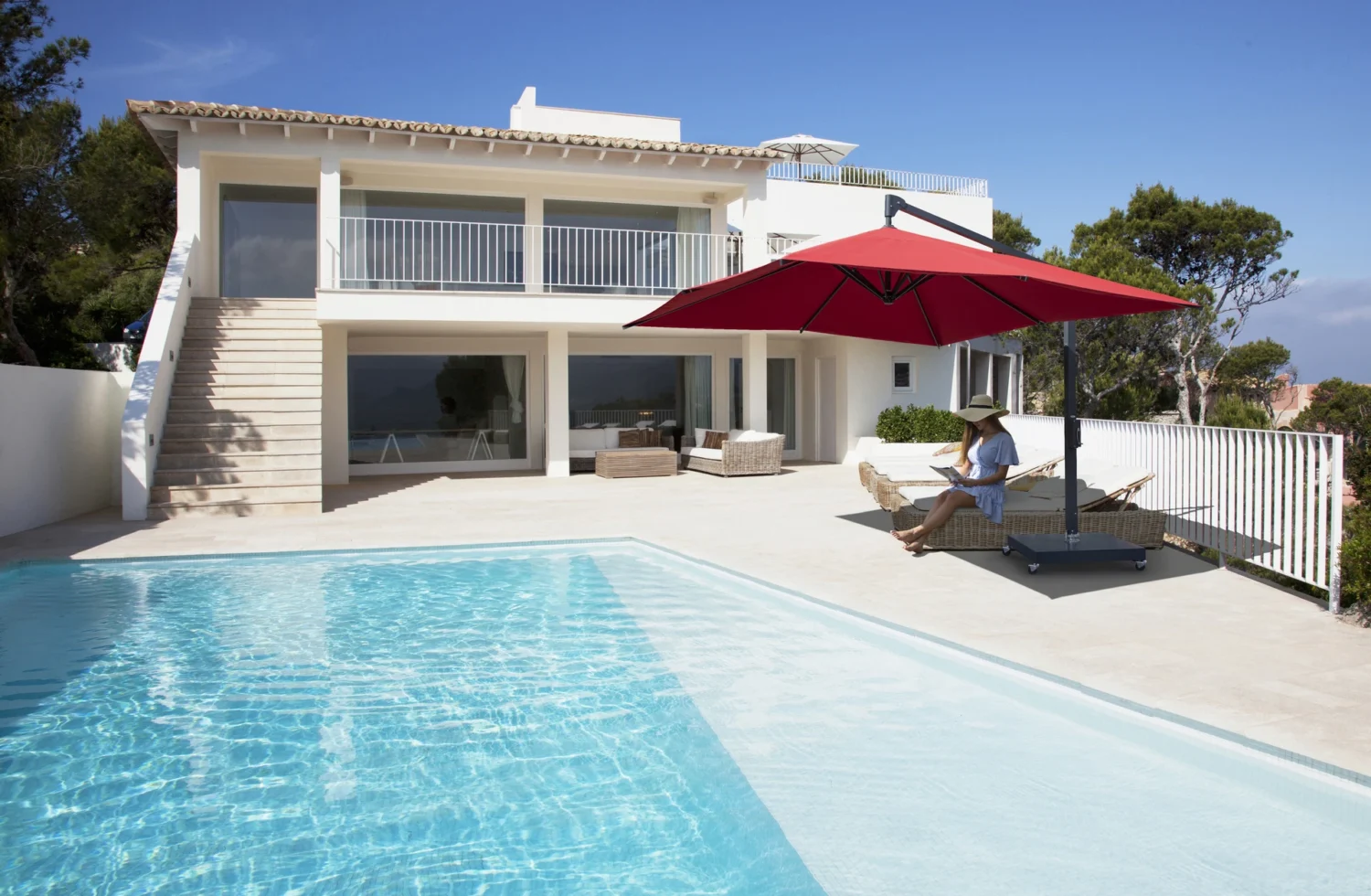Moderne Villa mit Pool und rotem Sonnenschirm